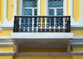 Iron balcony on the yellow plastering wall. Toned