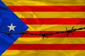 Iron barbed wire against the background of the national silk flag autonomy of Spain Catalonia, concept imprisonment for offenders