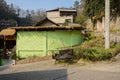 Iron bench outside green-painted teahouse on slope