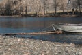 Iron boat is tied with rope to wooden pier. Crossing spring river. Evacuation of people in high water Royalty Free Stock Photo