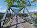 A tourist takes a photo on the old Ta Pai Memorial Bridge