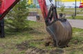 Excavator work. The iron ladle digs into the ground. Digging a hole.