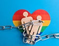 Iron chain figures of people on LGBT rainbow flag Royalty Free Stock Photo