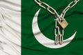 Iron chain and lock on the silk national flag of Pakistan with beautiful folds, the concept of a ban on tourism, political