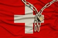 Iron chain and lock on the silk national flag of Switzerland with beautiful folds, the concept of a ban on tourism, political