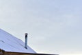 The iron chimney pipe that is covered with snow in winter