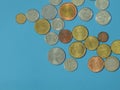 Iron coins of many countries and different currencies on a blue background. Royalty Free Stock Photo