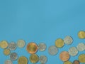 Iron coins of many countries and different currencies on a blue background. Royalty Free Stock Photo