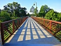 Iron and concrete footbridge crossing into a park