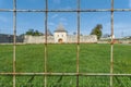 Iron cube fence with castle wall and tower with green grass in the background Royalty Free Stock Photo