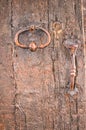 Iron door knocker, handle and lock, on a 1500\'s year old wood door, in Italy Royalty Free Stock Photo