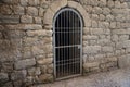 Iron door in a stone wall. Iron grate in the wall