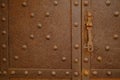 Iron door with studs and lock. Rusted iron sheet of an ancient door. It has mullioned windows with marble columns Royalty Free Stock Photo