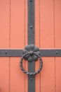 Iron doorknocker on orange wooden door