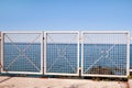Iron fence with blue sea and sky in the background Royalty Free Stock Photo