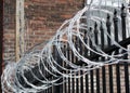 Iron fence with razor and barbed wire Royalty Free Stock Photo