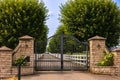 Iron front gate of a beautiful luxury home. Fancy large mansion behind a locked gate Royalty Free Stock Photo