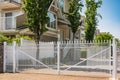 Iron front gate of a house. Wrought iron white gate and brick pillar.Classical design white wrought iron gate in suburb Royalty Free Stock Photo