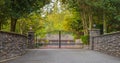 Iron front gate of a luxury home. Wrought iron gate and brick pillar. Nobody, street photo Royalty Free Stock Photo