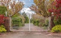 Iron front gate of a luxury home. Wrought iron white gate and brick pillar Royalty Free Stock Photo