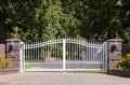Iron front gate of a luxury home. Wrought iron white gate and brick pillar Royalty Free Stock Photo