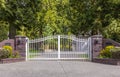 Iron front gate of a luxury home. Wrought iron white gate and brick pillar Royalty Free Stock Photo