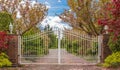 Iron front gate of a luxury home. Wrought iron white gate and brick pillar Royalty Free Stock Photo