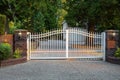 Iron front gate of a luxury home. Wrought iron white gate and brick pillar Royalty Free Stock Photo