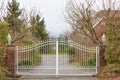 Iron front gate of a luxury home. Wrought iron white gate and brick pillar Royalty Free Stock Photo