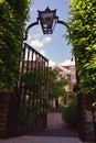 Iron gate door with the lantern leading to the private garden and house