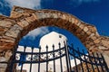 Iron gate and stone arch in Mykonos, Greece. Archway structure or architecture. Whitewashed building on sunny outdoor