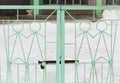 Iron gates with metal figures of people of light green color Royalty Free Stock Photo