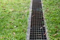 Iron grate of water drain in grass garden