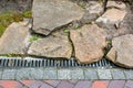 Iron grating line of the drainage system of the pedestrian sidewalk made of stone. Royalty Free Stock Photo