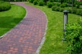 Iron ground lantern garden lighting with curved path paved stone tiles in park. Royalty Free Stock Photo