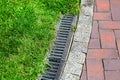 iron gutter with grate to the drainage system on the side of the pedestrian walkway.