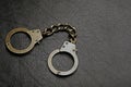 Iron handcuffs dark leather background