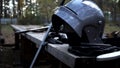 Iron helmet, sword and leather gloves are standing at the wooden table