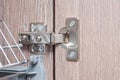 Iron hinge of kitchen furniture without closers. The mechanism for closing doors in the nightstand. Self-assembly Royalty Free Stock Photo