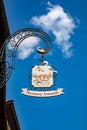 iron historic symbol and signage of a biscuiterie with figures of the pattiseur and a big cake