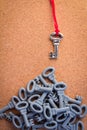 Iron key with red ribbon hanging from grey keys Royalty Free Stock Photo