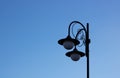 An iron lantern against the blue sky. Road lighting, light bulbs in a lamppost Royalty Free Stock Photo