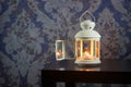 Iron lantern with white candle inside on wooden table Royalty Free Stock Photo