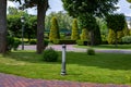 Iron lanterns of street lighting in the park with stone tile pedestrian sidewalks and green lawns. Royalty Free Stock Photo