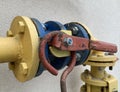 Iron lever on the gas pipe. Pipeline gas separation valve. Yellow-blue gas pipe with damper