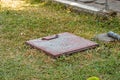 an iron lid on a water reservoir in the middle of the grass Royalty Free Stock Photo