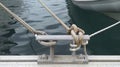 Iron mooring with ropes. Nautical ropes close up. Mooring yacht rope with a knotted end tied around a cleat Royalty Free Stock Photo