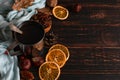 Iron mug with black coffee, spices, dry oranges, on a background of a scarf, dry leaves on a wooden table. Autumn mood, a warming Royalty Free Stock Photo