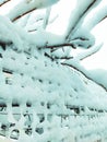 Iron net fence covered snow. Metal rusty fence-mesh netting in the snow. Close-up shot of snow on a fence. Lattice fence covered Royalty Free Stock Photo