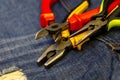 Iron nippers red yellow rubber grips tool construction repair on blue jeans background Royalty Free Stock Photo